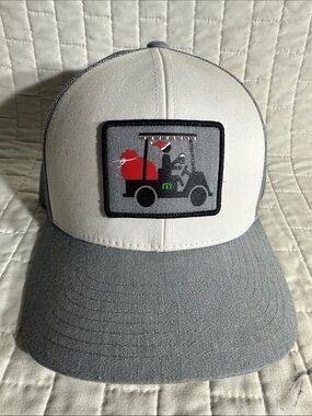 Travis Mathew snapback trucker hat features a Christmas-themed golf cart graphic